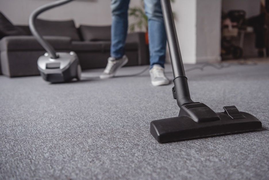 Professional cleaner using a commercial-grade vacuum.