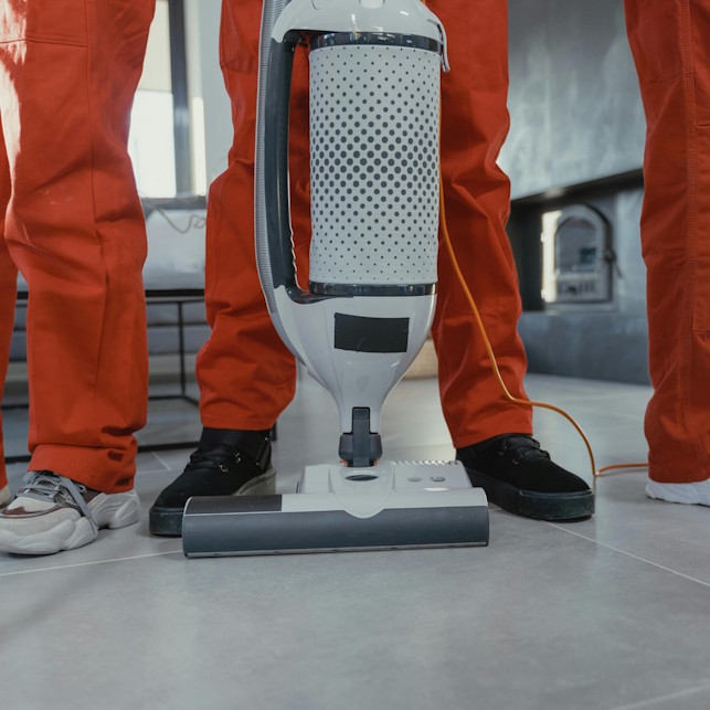 Cleaners standing with a commercial vacuum.